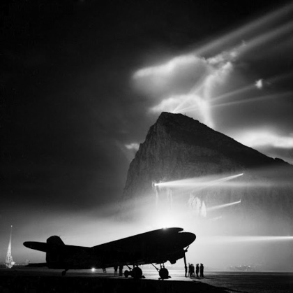 A-Douglas-Dakota-of-the-British-Overseas-Airways-Corporation-at-Gibraltar-silhouetted-by-searchlights-on-the-Rock-1940-45.jpg
